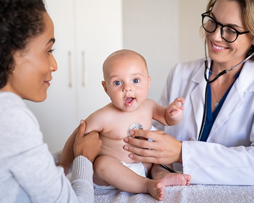 Doctor examining baby with stethoscope.