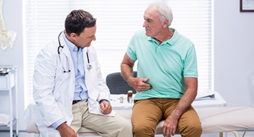 Patient telling doctor about his pain in belly.