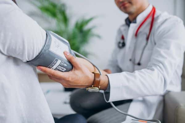 Doctor checking blood pressure of patient manually.