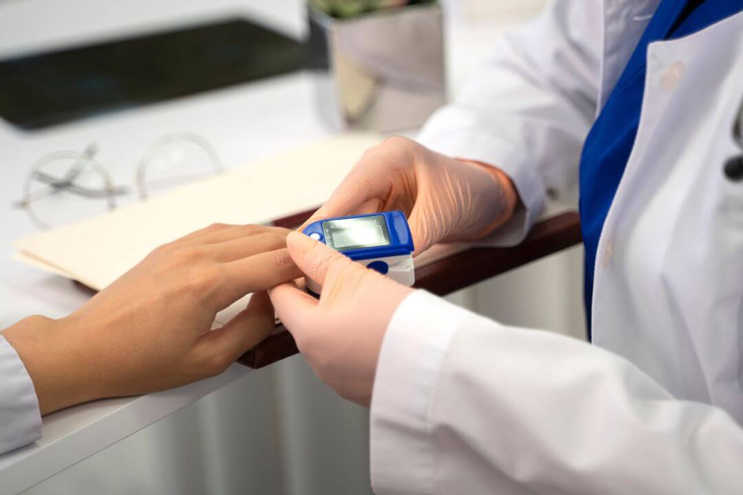 Doctor using pulse oximeter on patient