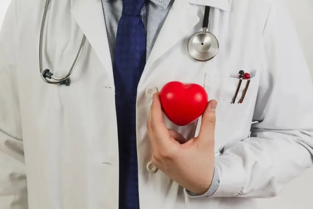 Doctor holding red heart, symbolizing care.