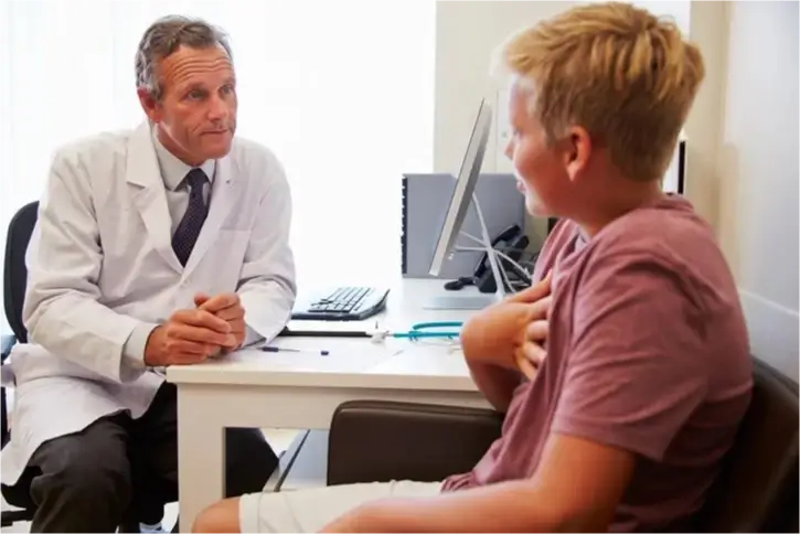 Doctor discussing health with young boy.